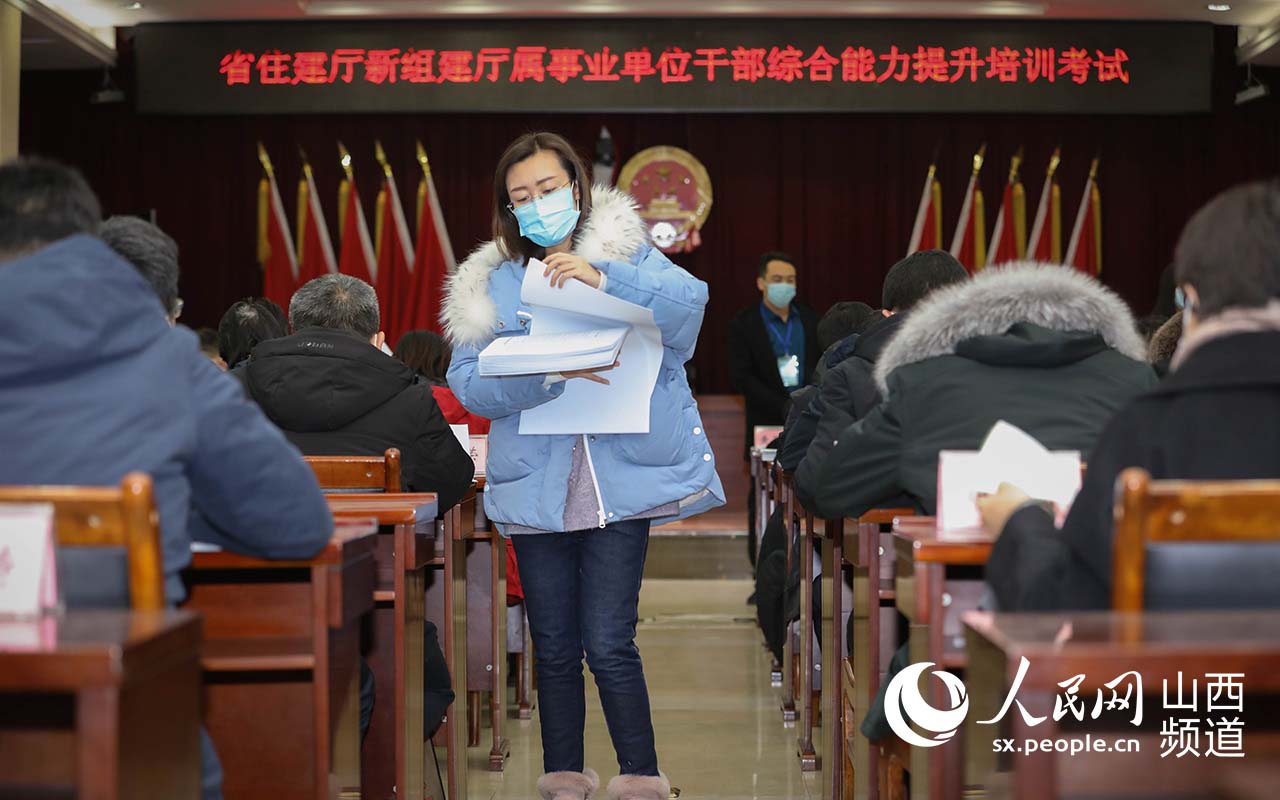 1月30日，山西省住建廳考試現場，工作人員有序發放考卷。