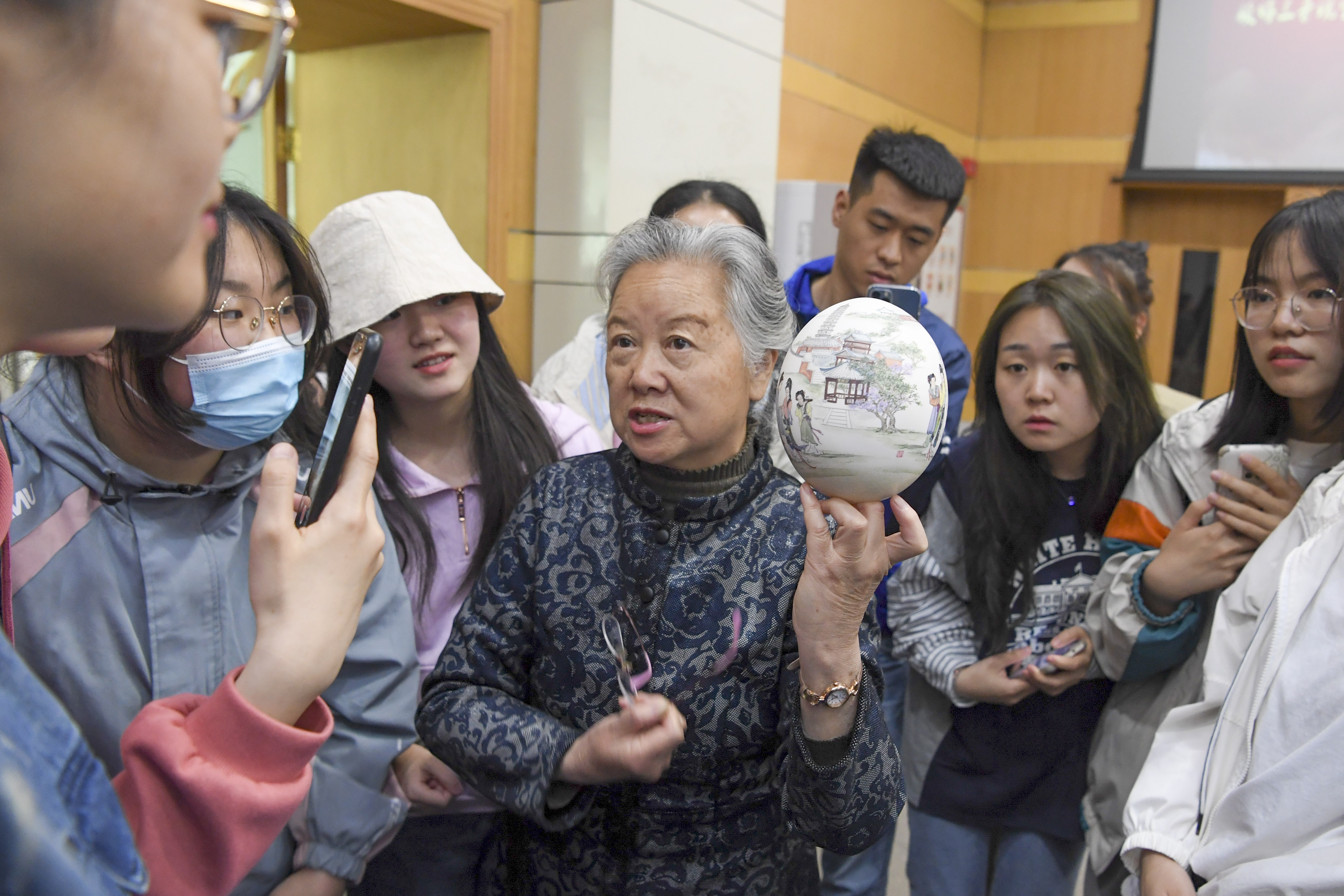 山西省工藝美術大師龔曉華正在為學生們講解彩蛋畫背后的故事——《西廂記》