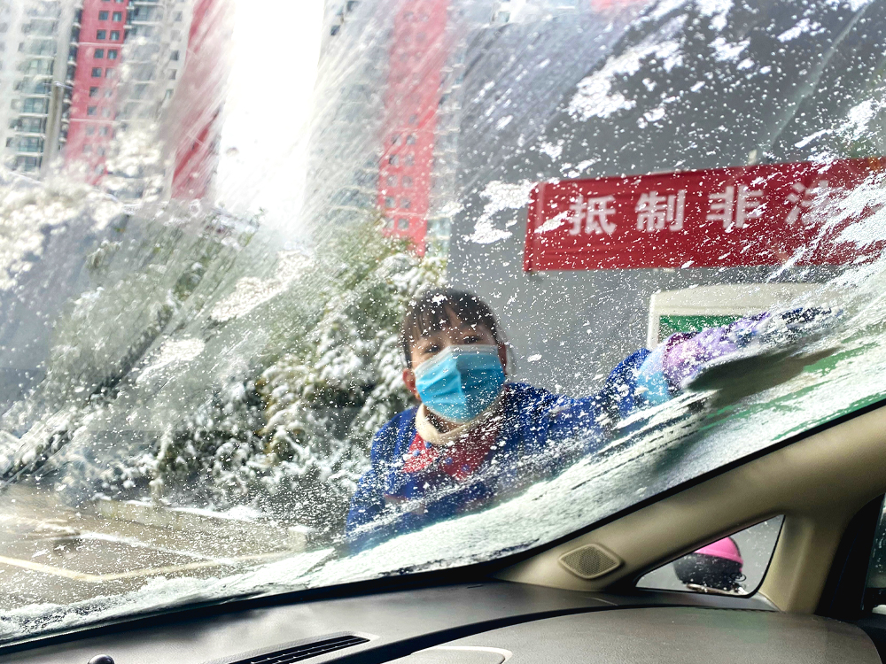 加油站員工主動為顧客清掃車身積雪、擦拭擋風玻璃。