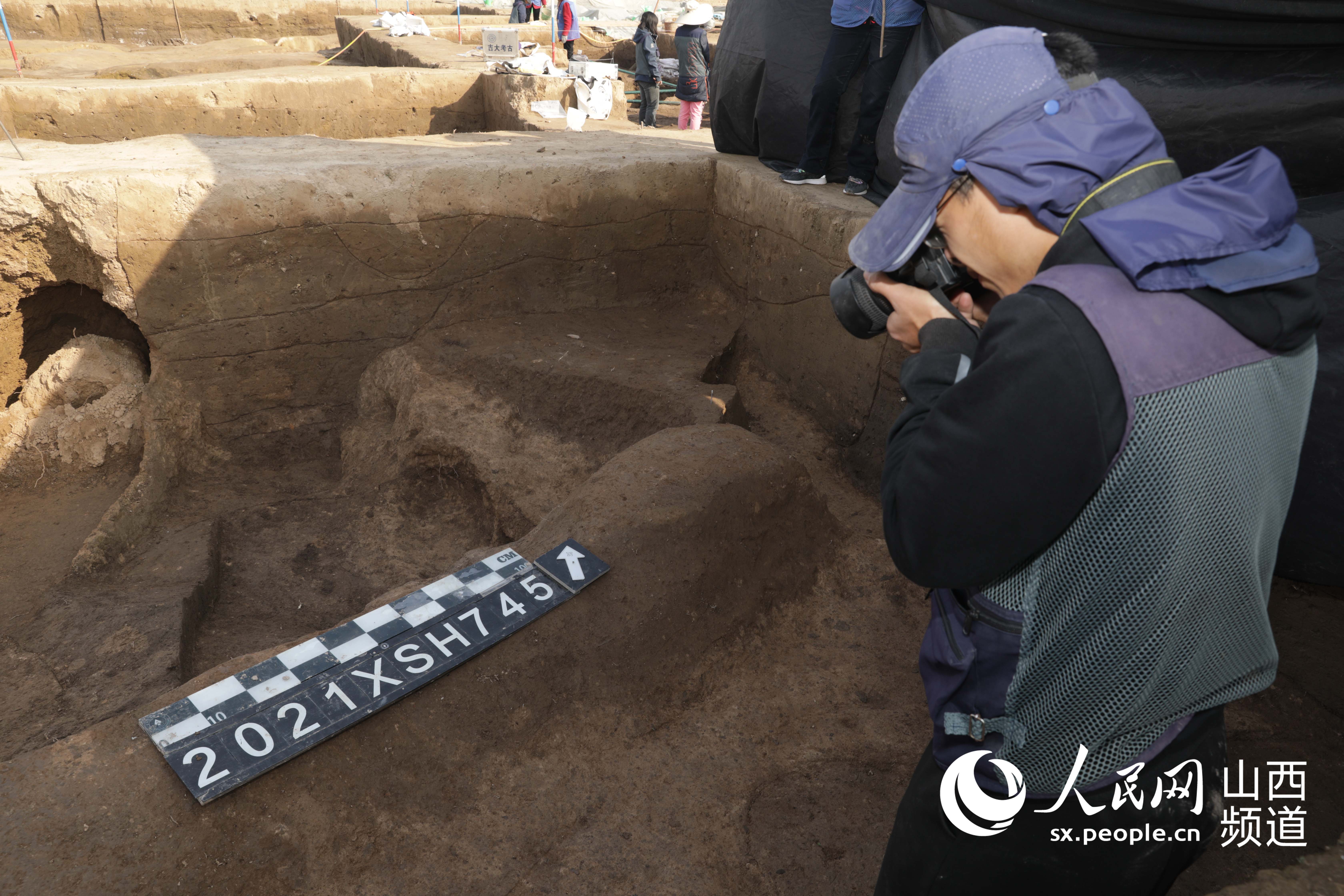 吉林大學考古學院學生對新發掘的遺址拍照