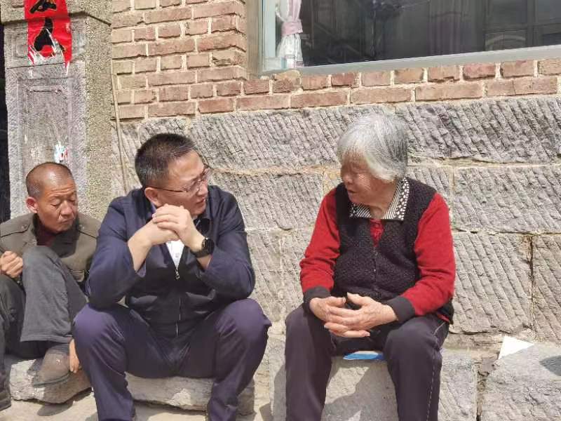 梁海昌与仙人乡山南村村民交谈，了解家庭生产生活情况。
