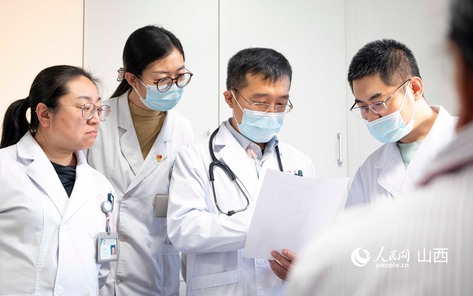 11月21日，北大医院常驻专家肾内科主任医师许戎（左三）带领医生查房。人民网记者 卢鹏宇摄