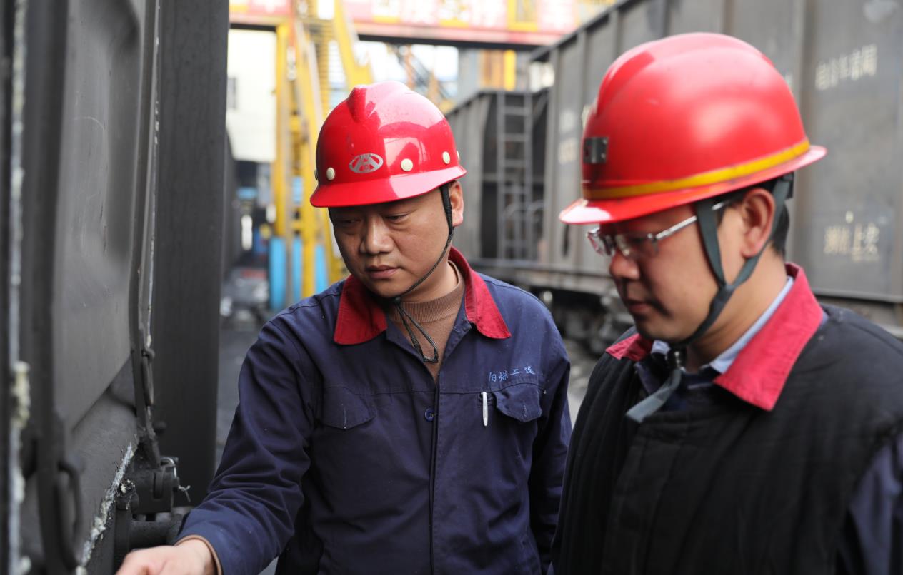 二矿装运队队长董志勇正在对外运车辆的门锁装置进行检查
