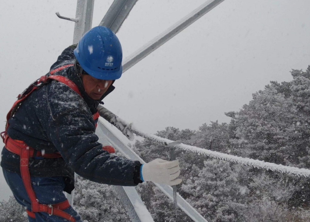 2月20日，国网晋城供电公司输电运检中心员工在220千伏尖坪线18号模拟导线进行覆冰取样检测。张浩然摄