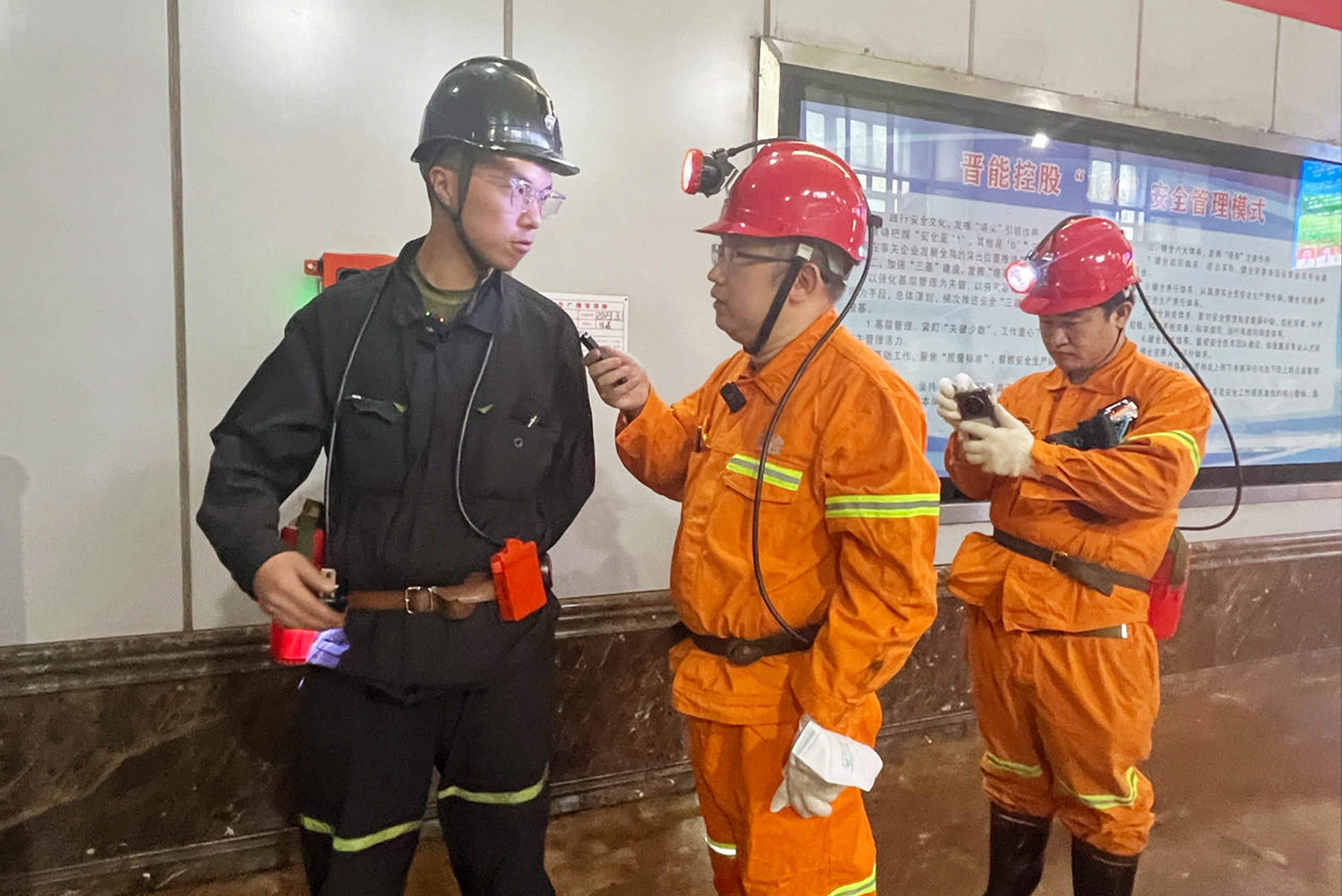 采访团成员在矿区与矿工交流。人民网记者邓志慧摄