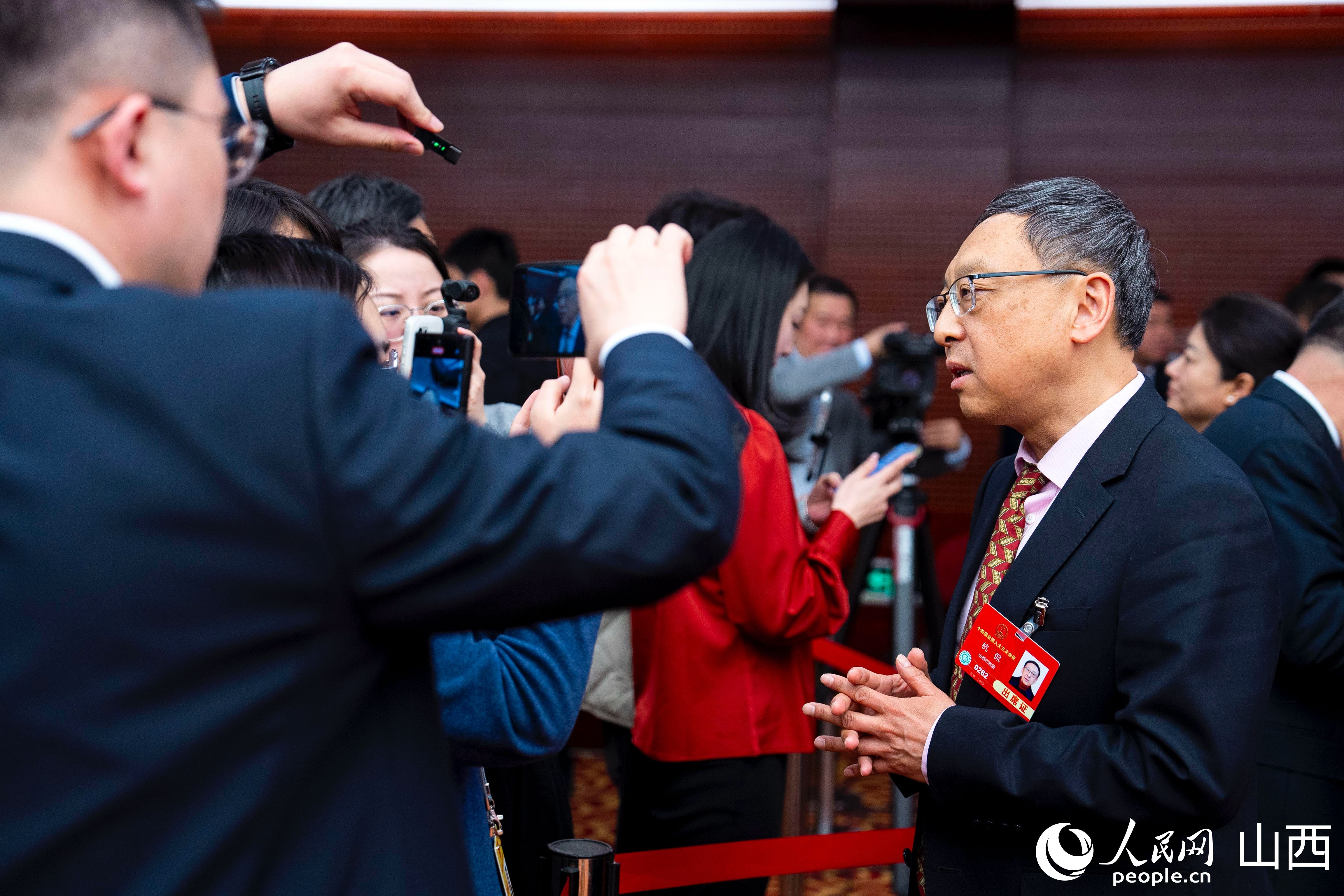 会议结束后，记者们围着杭侃代表采访。