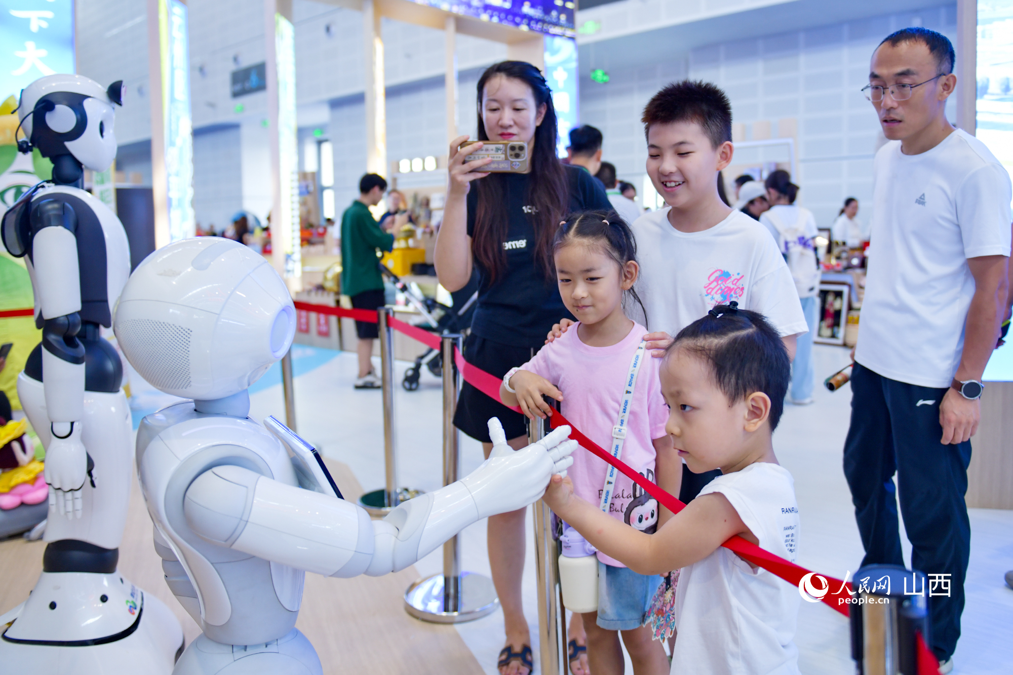 小觀眾和機器人聊天“交朋友”。人民網記者 焦搏文攝