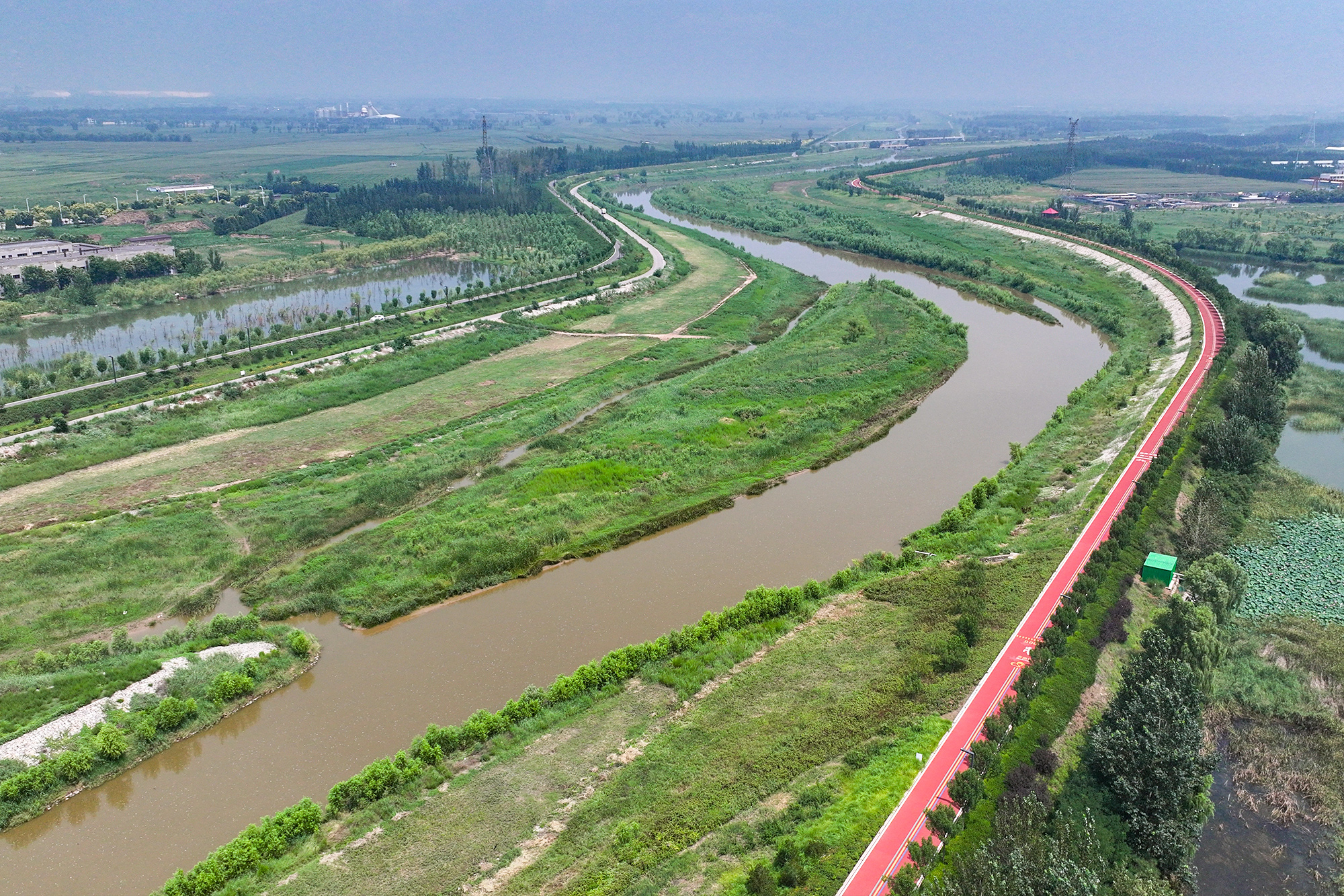山西省晋中市介休汾河国家湿地公园内，沿河蜿蜒的塑胶跑道，成为人们休闲健身的好去处。王璟摄