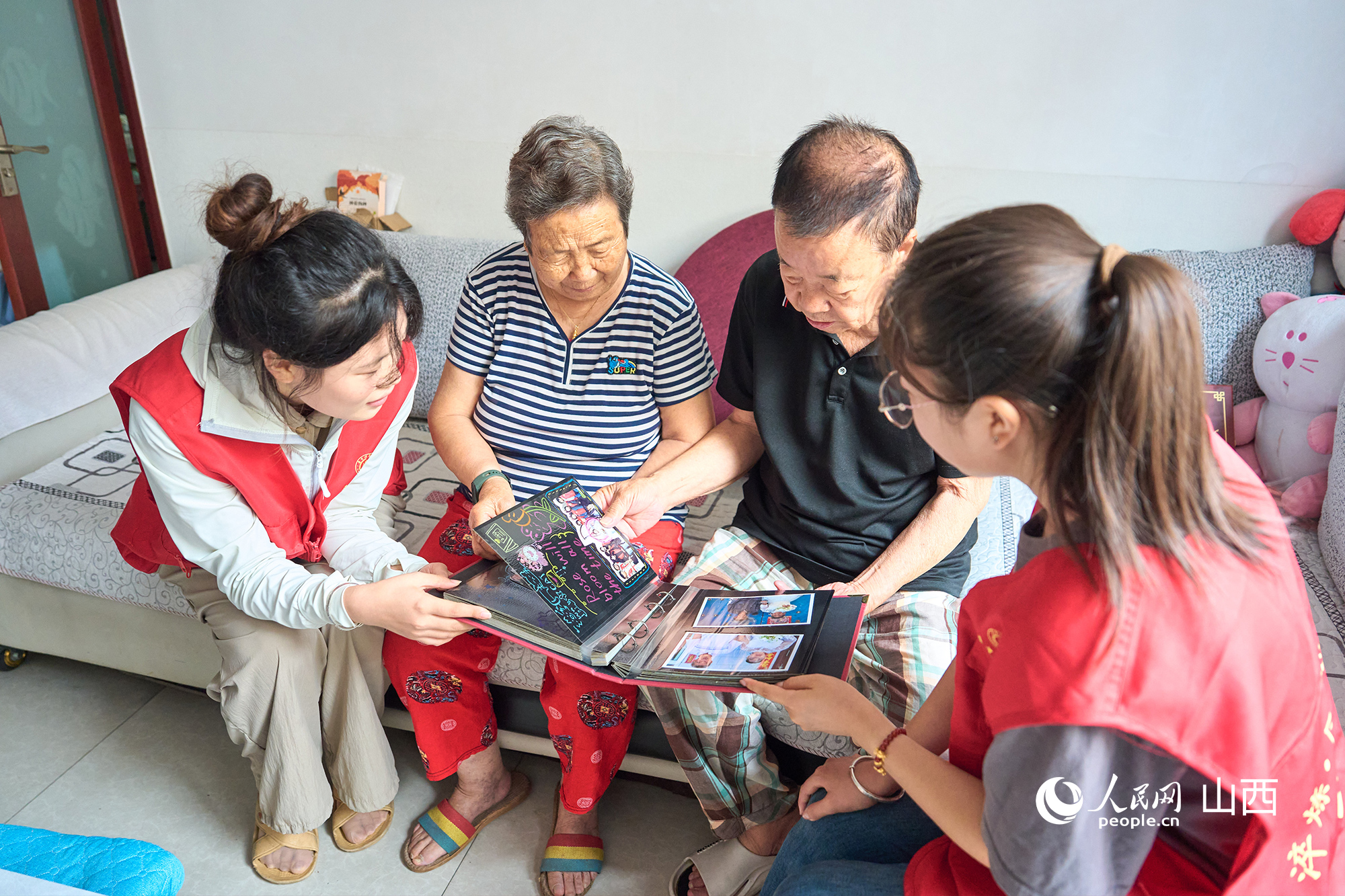志愿者和老人一同看“时光纪”相册。张超宁摄