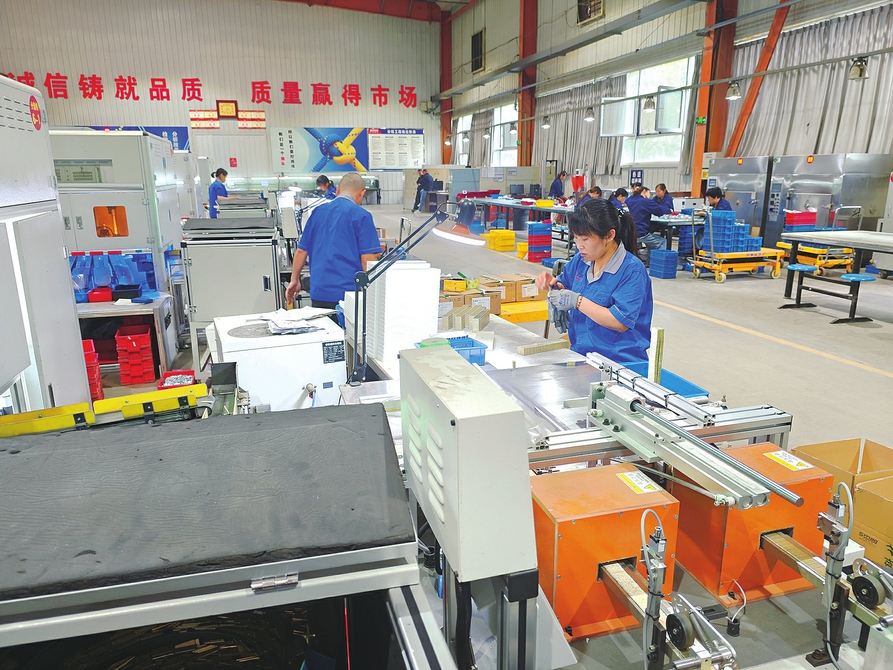 工人正在分揀車間檢驗、包裝電機磁鋼產品。周明飛攝