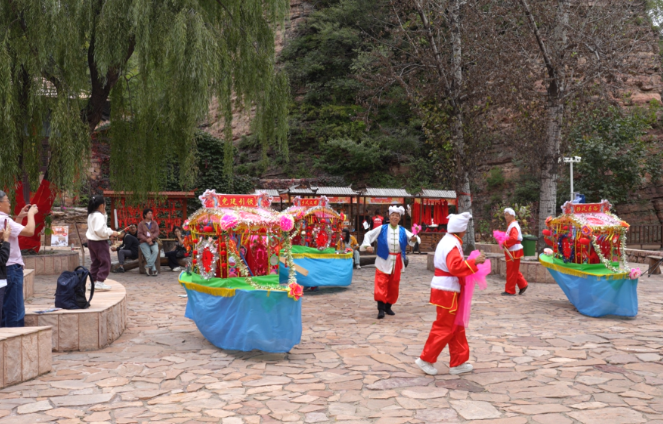 游客在黄崖洞文化旅游区观看民俗表演