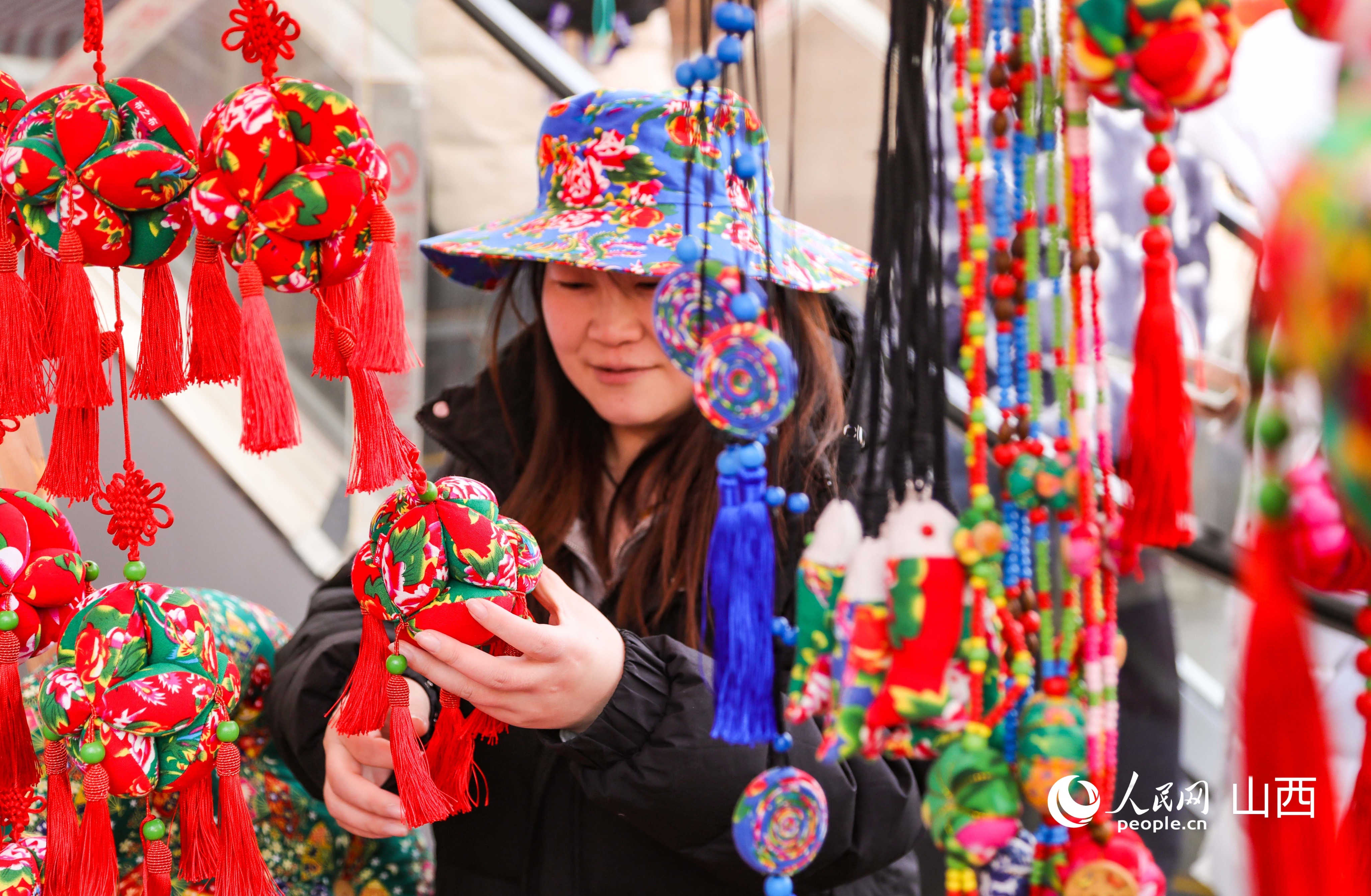 一位女士在挑选高平特色香包。人民网记者 王帆摄