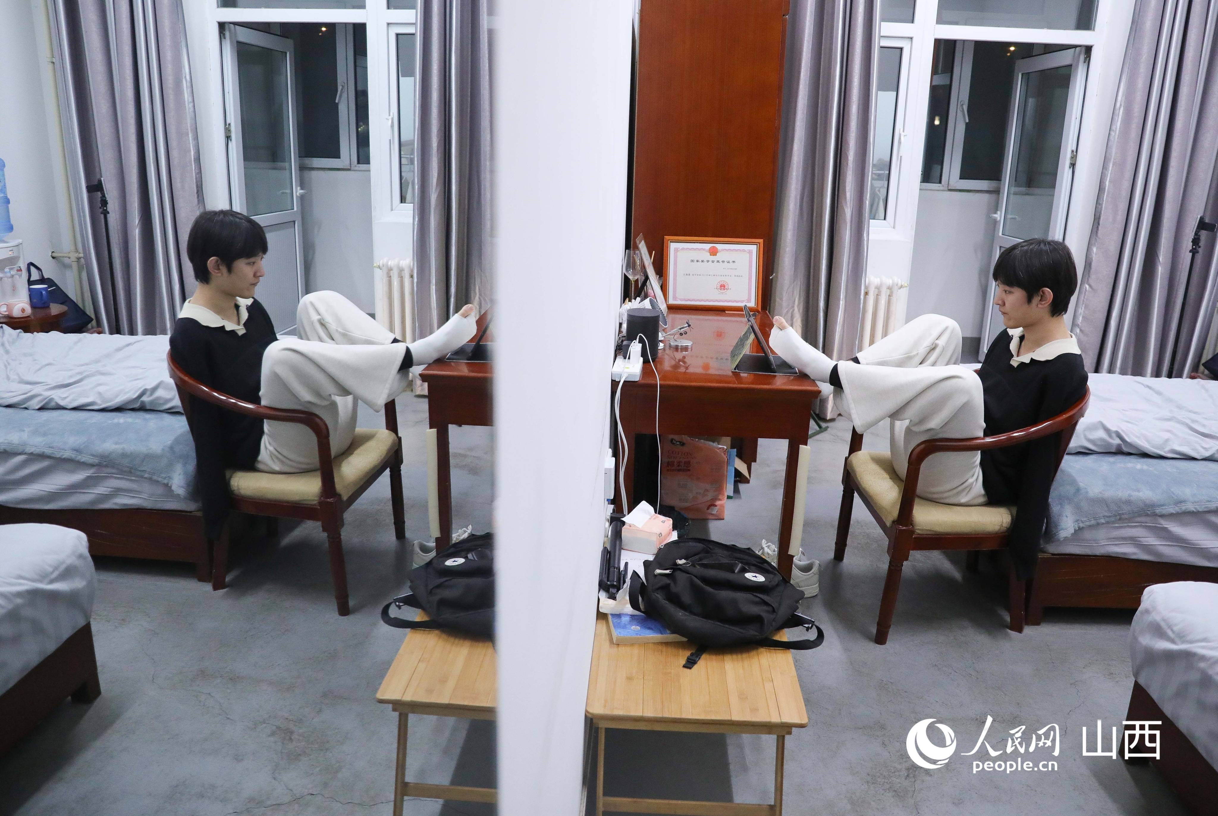 王海港在學校提供的單人間宿舍內忙碌。人民網記者 王帆攝