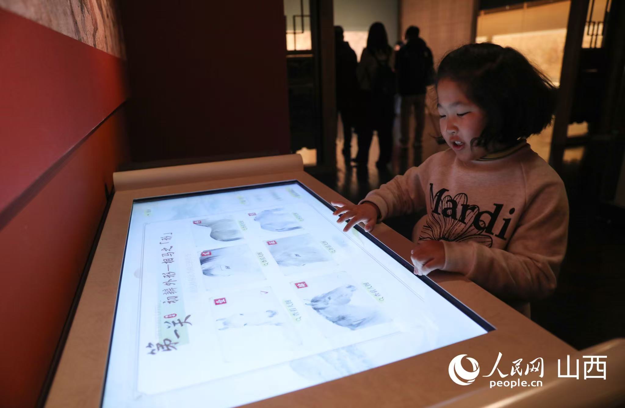 小朋友正在体验相马经游戏。人民网记者 王帆摄