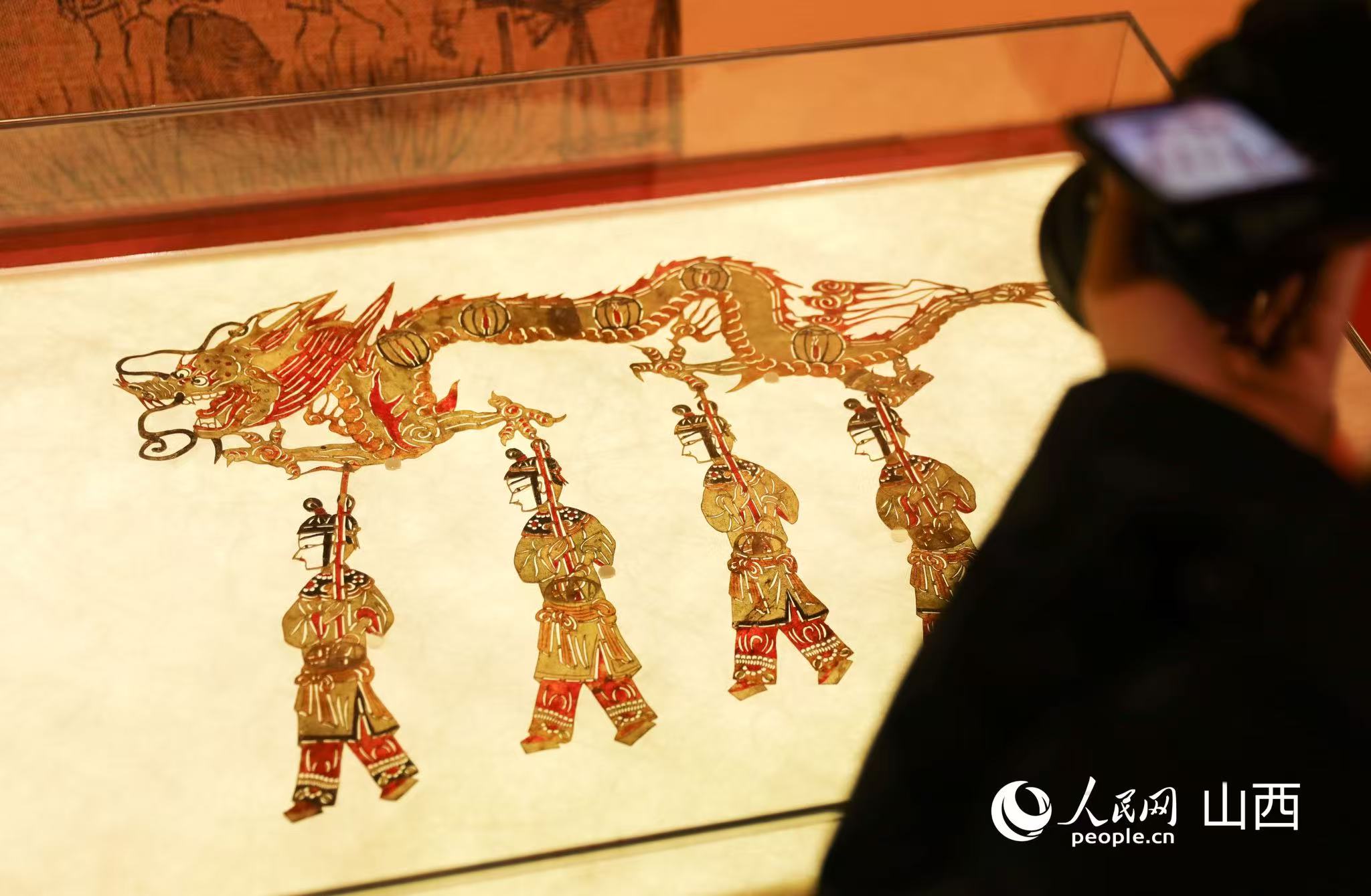 现场展出的古代“舞龙”元素皮影文物。人民网记者 王帆摄