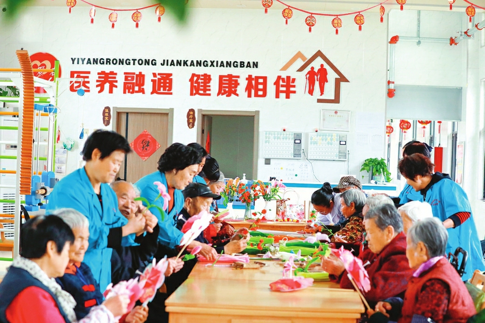 临猗县孙吉镇中心卫生院医养苑的老人们在制作手工艺品。通讯员王革摄