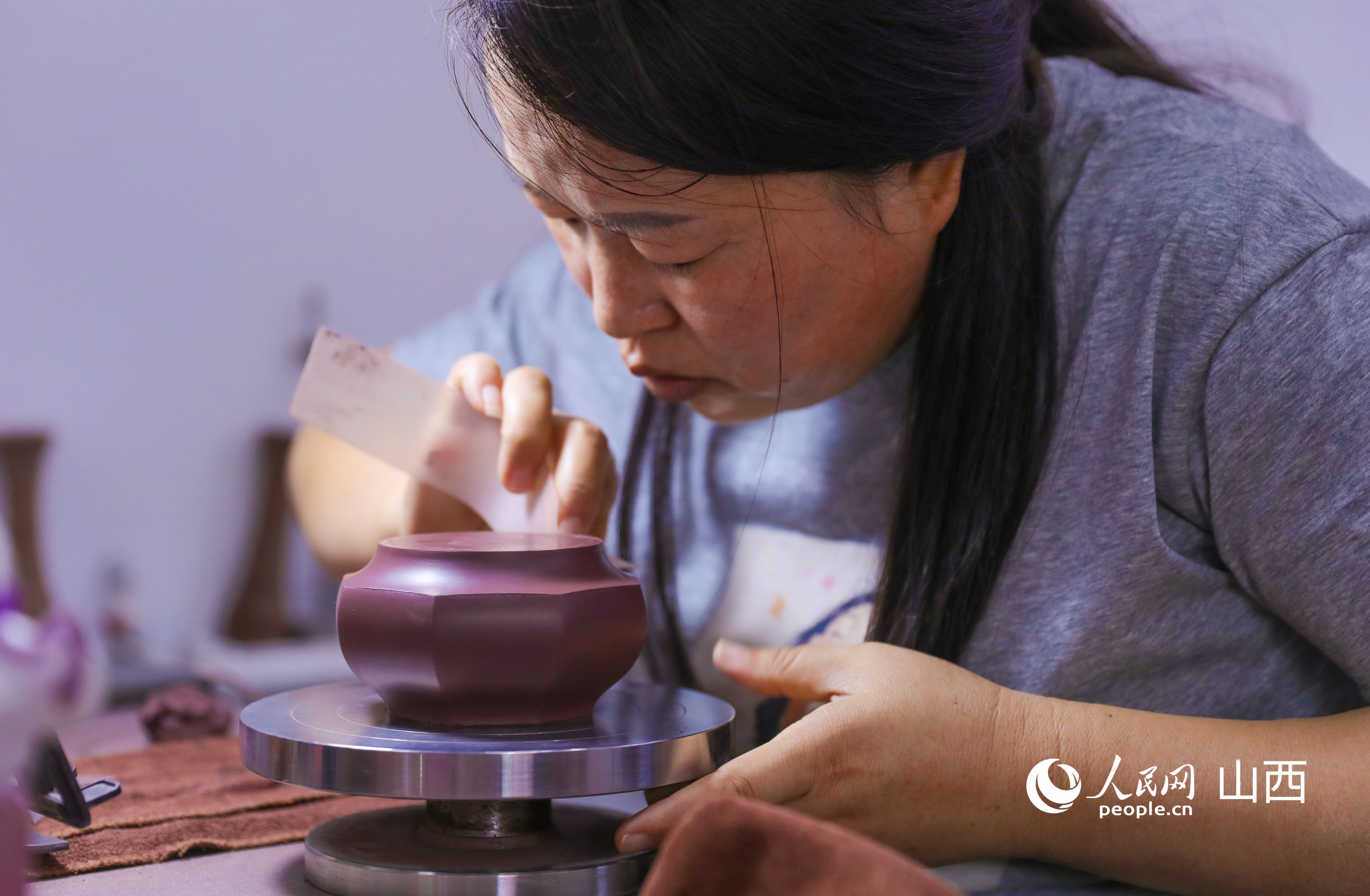 抿针既是制壶工具，也是精加工工序，有效降低烧制开裂概率，优化养壶质感。人民网记者 王帆摄