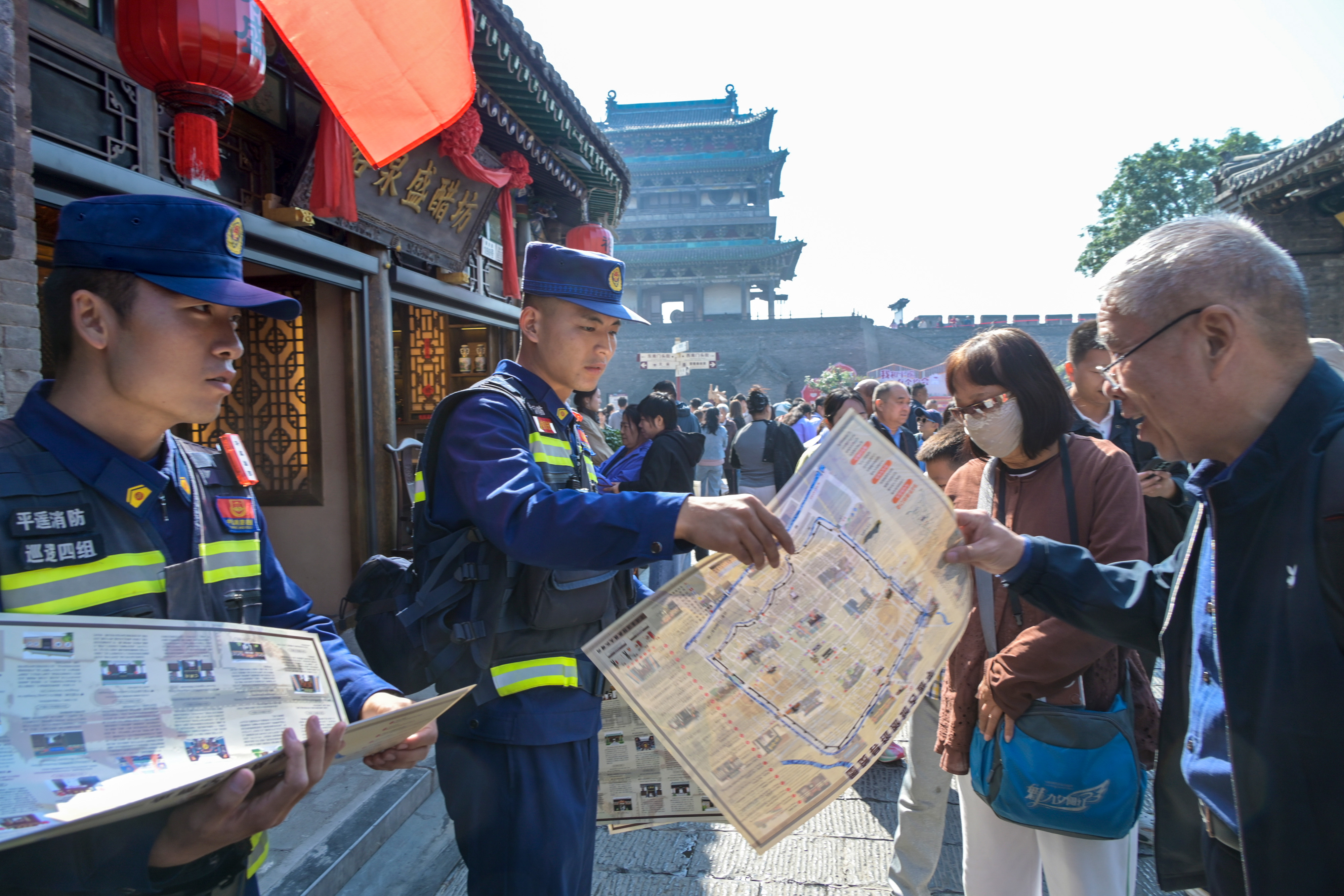 消防员在古城内分发导览图。梁生仁摄